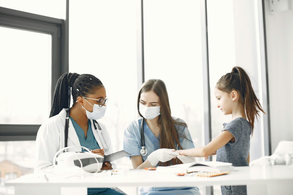 pexels-photo-7446995-7446995 Healthcare professionals attending to a child indoors during a medical check-up.
